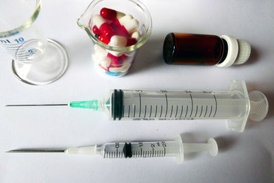 High angle view of injection and medicines on table