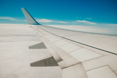 Airplane wing against blue sky