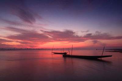 Scenic view of sea against dramatic sky during sunset