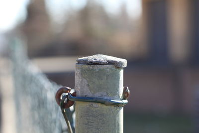 Close-up of rusty chain on wooden post