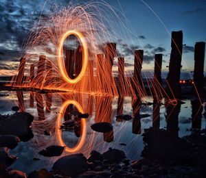 Illuminated wheel against sky at night