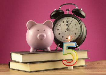 Electric lamp on table against pink background