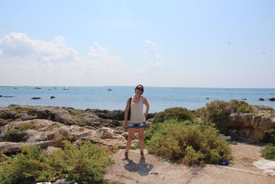 Portrait of man standing on beach against sky