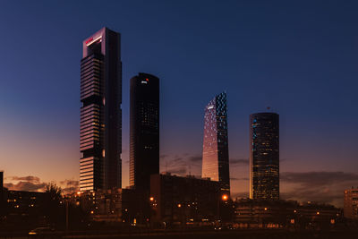 Low angle view of illuminated buildings against sky at dusk