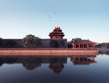 Historical building reflecting in lake against clear sky