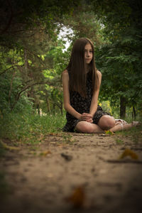 Young woman sitting in forest