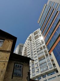 Low angle view of modern buildings against clear blue sky