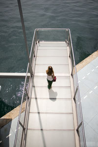 High angle view of woman on staircase by swimming pool