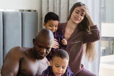 Mixed race family sitting in bed