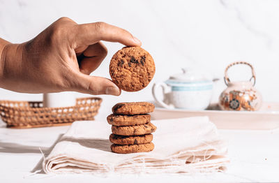 Midsection of person holding cookies on table