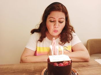 Portrait of young woman blow the birthday cake