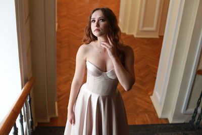 High angle view of beautiful woman wearing dress while standing on staircase