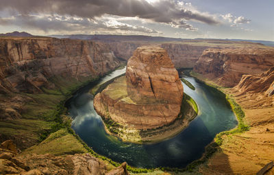 High angle view of horseshoe bend against cloudy sky