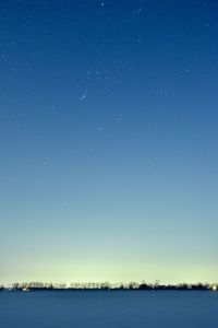 Scenic view of lake against clear blue sky at night