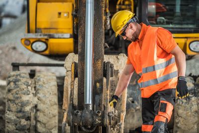 Engineer standing by earth mover at construction site