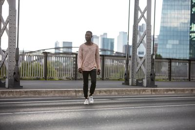 Full length of young man walking on road