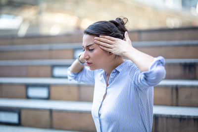 Woman looking away while standing outdoors