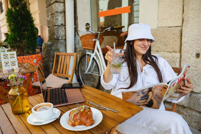 Portrait of smiling friends using digital tablet while sitting on table