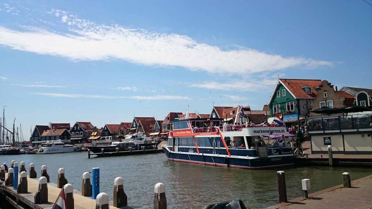 nautical vessel, architecture, transportation, building exterior, built structure, water, mode of transport, boat, moored, sky, waterfront, cloud - sky, sea, cloud, harbor, day, blue, outdoors, passenger craft, no people, red, ocean, residential district