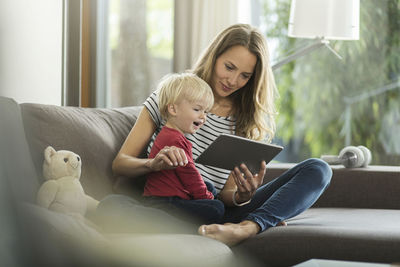 Mother and son on couch with digital tablet