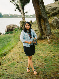 Portrait of young woman standing on field