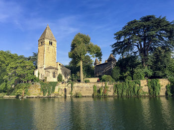 Historic building by lake against sky