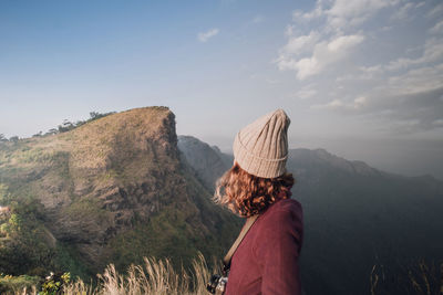 Side view of woman standing against sky