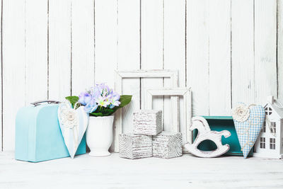 White flowers on table against blue wall