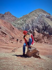 Rear view of woman sitting on mountain