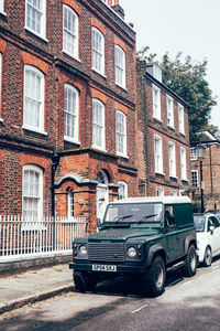 Cars on street by buildings against sky