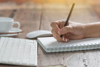 Close-up of hand using laptop on table