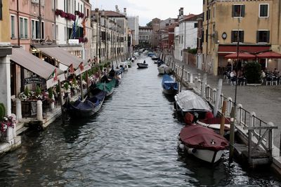 Boats in canal amidst buildings in city