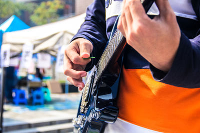 Midsection of man playing guitar