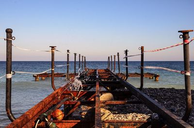 Wrought iron jetty leading to calm blue sea