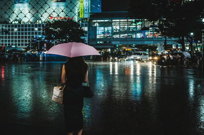 People walking on wet glass during rainy season at night