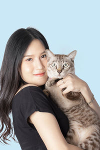 Portrait of smiling young woman with cat