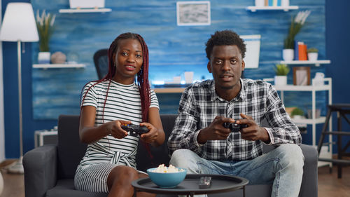 Portrait of couple playing game at home