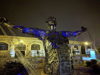 Statue of illuminated building at night