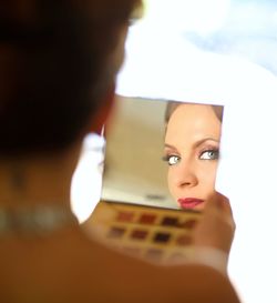 Close-up portrait of young woman holding camera