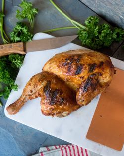 High angle view of roast chicken in cutting board