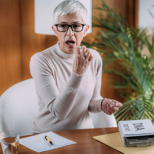 Mid adult woman sitting on table