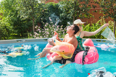 High angle view of girl floating in swimming pool