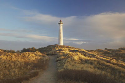 Lighthouse by sea against sky