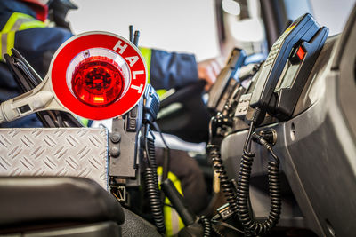 Close-up of telephone with firefighter driving fire engine