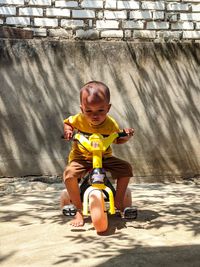 Full length of cute boy sitting outdoors