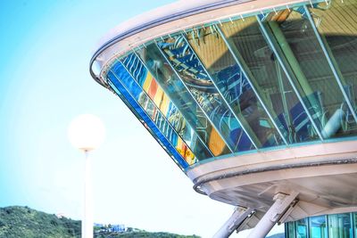 Low angle view of ferris wheel against clear blue sky