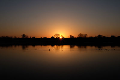 Scenic view of lake against sky during sunset