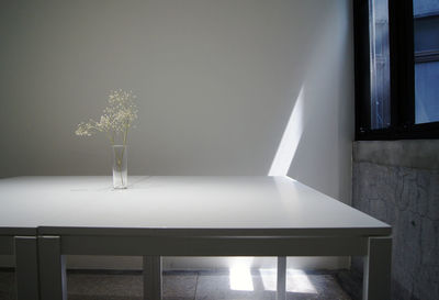 Vase on table against wall