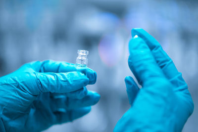 Cropped hand of scientist holding vial in laboratory