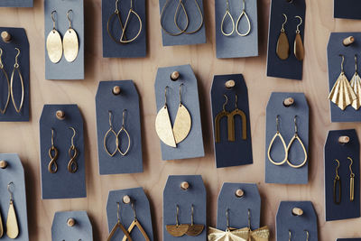 Earrings hanged on wooden rack at design studio